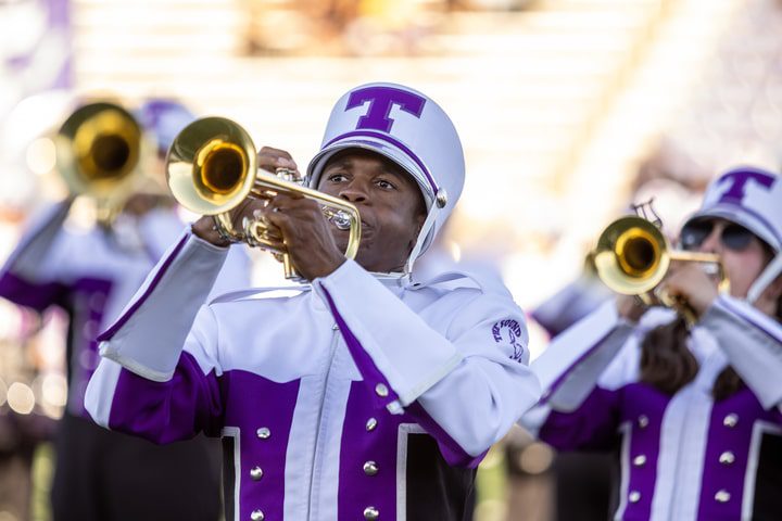 Black male student playing the trumpet in his band uniform