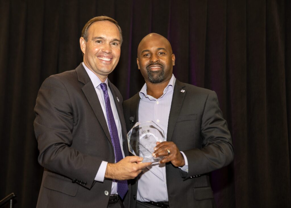 Dr. Hurley presenting Dr. Reggie Hall with a Last Lecture plaque.