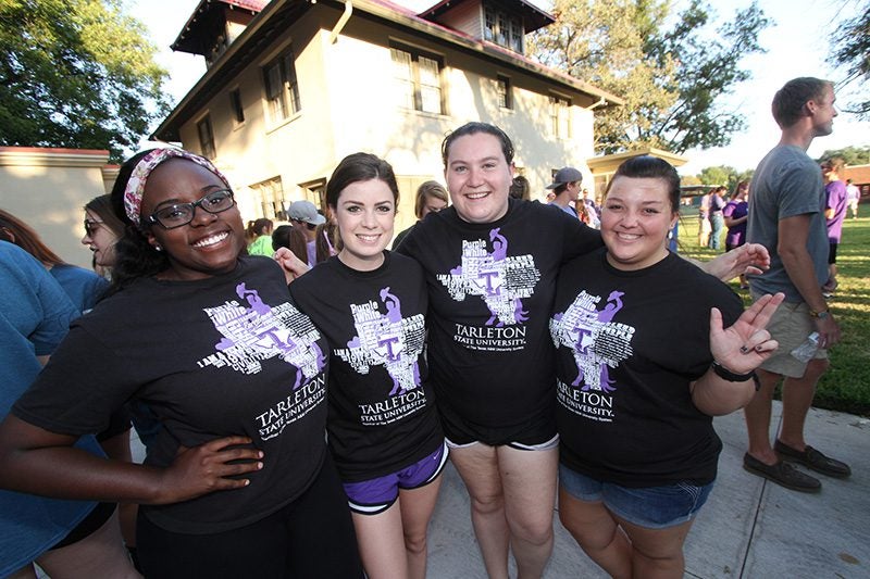 Four female students posing in front of the Trogdon House