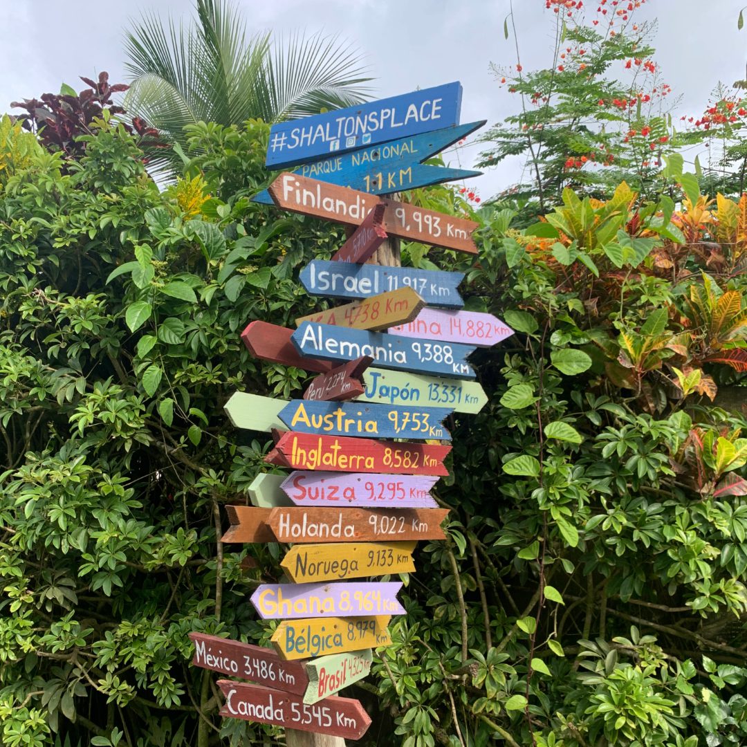 Wooden directional sign with greenery behind in Costa Rica. Where do you want to study abroad?